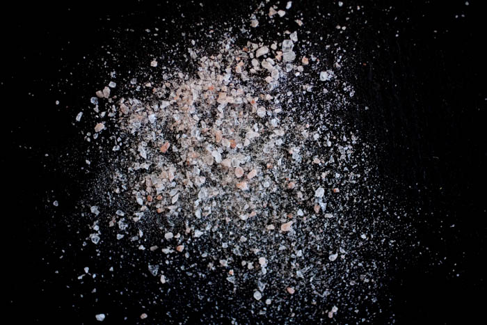 pile of pink salt on a black background 