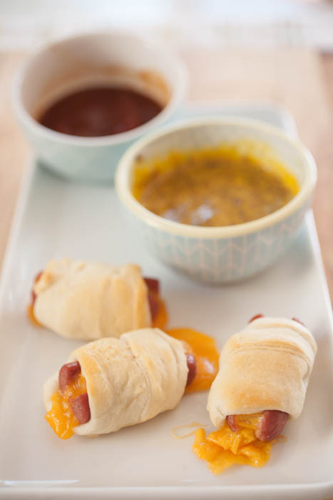 hot dogs with cheese covered in dough with two dipping sauces 