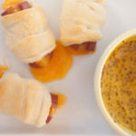 honey mustard sauce with cheese-filled and crescent-wrapped hot dogs.