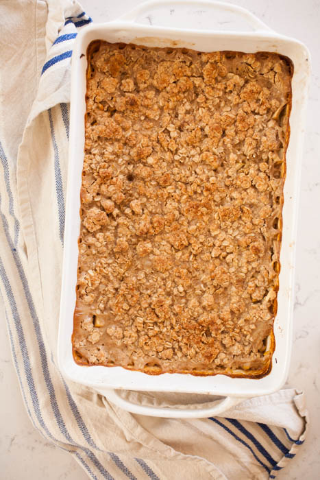 overhead shot of crisp oatmeal in white baking dish over a dish cloth