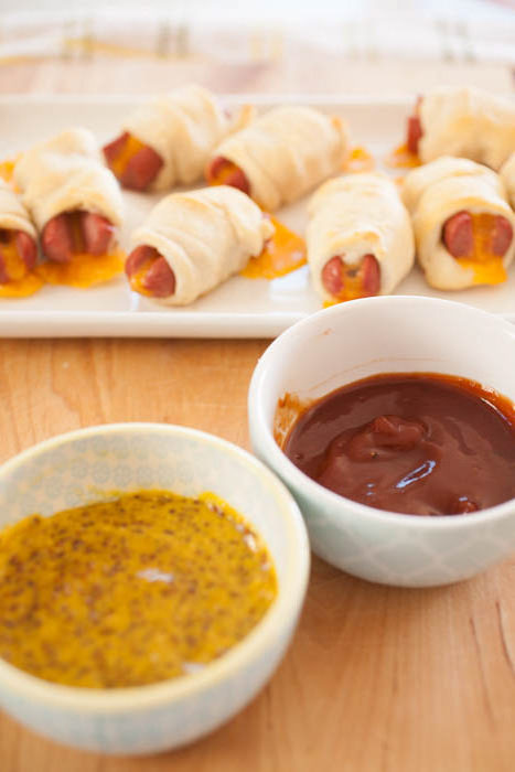 game-day dipping sauces on a cutting board in front of appetizers.