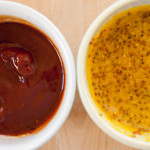 close-up of ketchup and honey mustard sauces to on a wooden cutting board