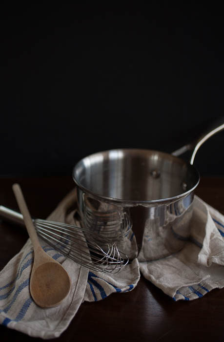 pot with whisk, wooden spoon, and dishcloth 