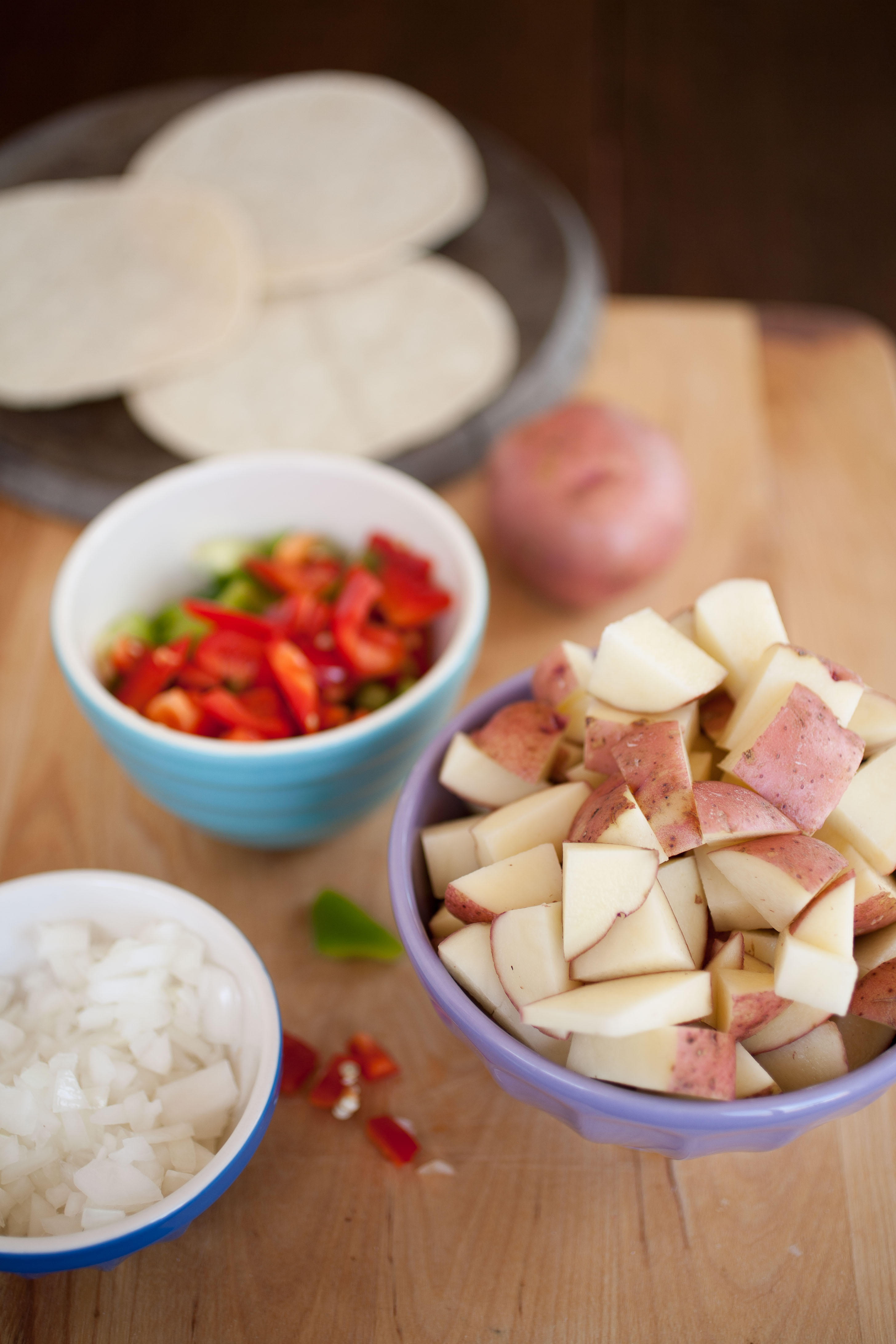 red potatoes, peppers, and onions in bowls