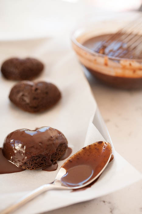 spoon, bowl of chocolate ganache, and heart-shaped cakes 