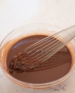 ganache in a glass bowl with a whisk