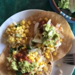 fish tacos with sautéed sweet corn on a white plate from Flurries of Flour